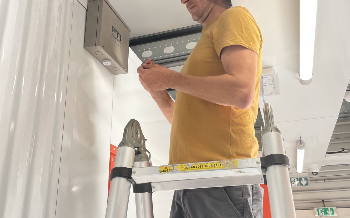 Technicien Kitech installant un équipement de contrôle d'accès dans un centre de self-stockage