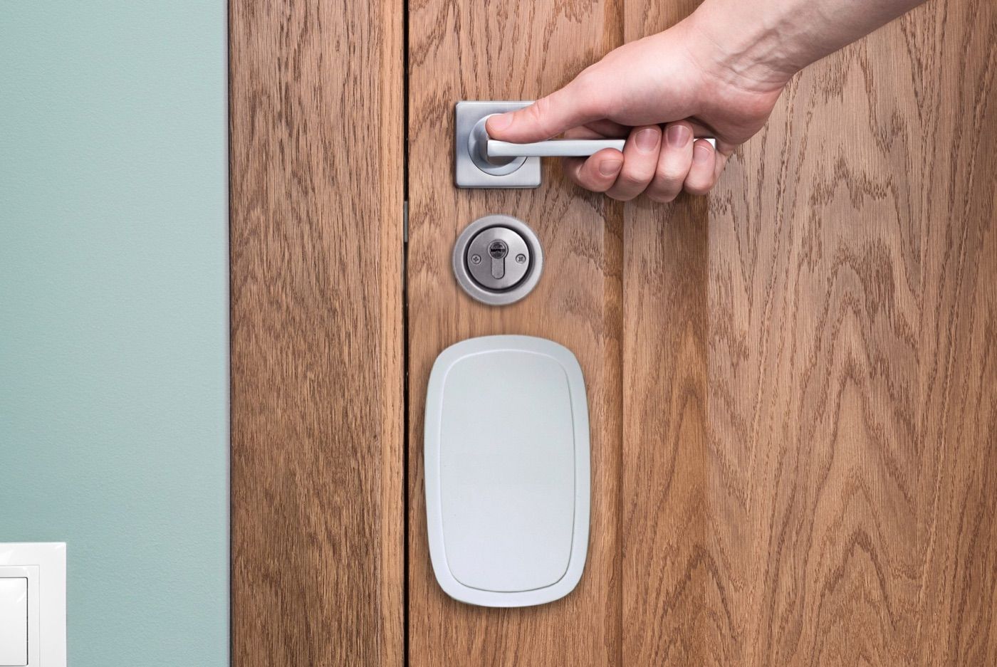 Alarme de porte intelligente Check'In fixée sur la face intérieure d'une porte d'entrée